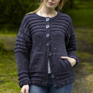 May include: A dark blue cardigan with a speckled texture, featuring a round neckline, button closure, and two pockets.