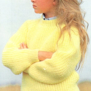 May include: A yellow knitted sweater with a crew neck and long sleeves. The sweater is made of a soft, textured yarn.