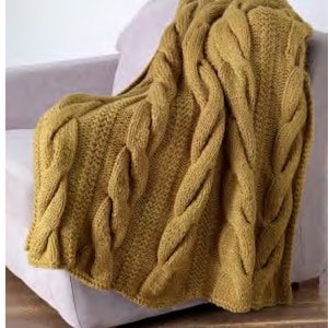 May include: A soft, yellow knitted throw blanket with a cable knit pattern. The blanket is draped over a light purple armchair.