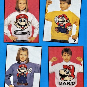 Puede incluir: Cuatro niños con suéteres de punto con un diseño de personaje de Mario. Los suéteres son blancos, amarillos, morados y blancos. Los suéteres tienen las palabras "Nintendo" y "Mario" en ellos.