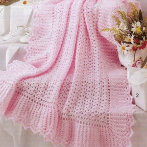 Op de afbeelding: Een roze gehaakte babydeken met een delicate gegolfde rand. De deken is gemaakt met een eenvoudig steekpatroon en is perfect voor een pasgeborene.