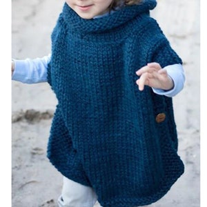 May include: A teal blue knitted hooded poncho with a wooden button. The poncho is made of a soft, textured yarn.