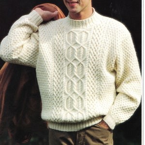 May include: A white knitted jumper with a cable knit pattern. The jumper has a high neck and long sleeves.