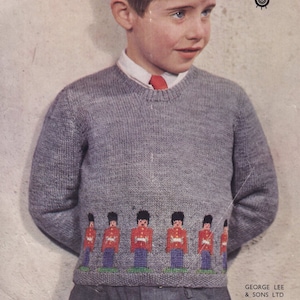 May include: A gray knitted sweater with a crew neck and a row of red, blue, and white toy soldier figures embroidered across the bottom.