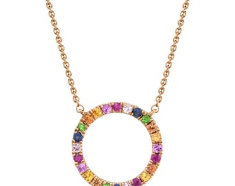May include: A rose gold necklace with a circle pendant set with colorful gemstones. The pendant is made of small round gemstones in shades of red, orange, yellow, green, blue, and purple.