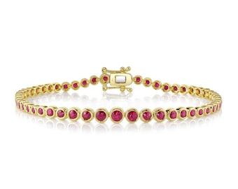 May include: A gold bracelet featuring a series of round, vibrant red gemstones. The bracelet has a delicate design with a secure clasp. The gemstones are evenly spaced along the gold chain, creating a continuous line of color. The bracelet is a piece of jewelry.
