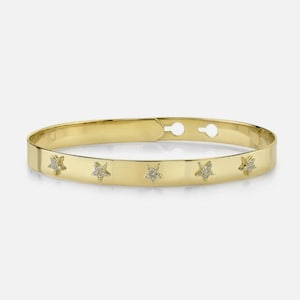 Op de afbeelding: Een gouden armband met vijf kleine stervormige accenten bezet met diamanten.