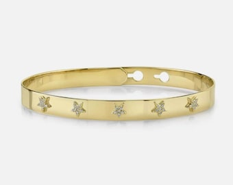 Puede incluir: Un brazalete de oro con cinco pequeños acentos en forma de estrella engastados con diamantes.
