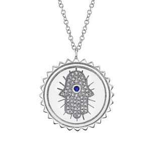 May include: A silver necklace with a round pendant featuring a hamsa hand with a blue evil eye and a diamond-like design.