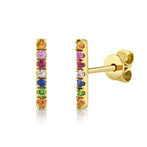Op de afbeelding: Een paar gouden staafjes oorbellen met een regenboog van edelstenen. De oorbellen zijn bezet met kleine, ronde edelstenen in verschillende kleuren, waaronder rood, oranje, geel, groen, blauw en paars.