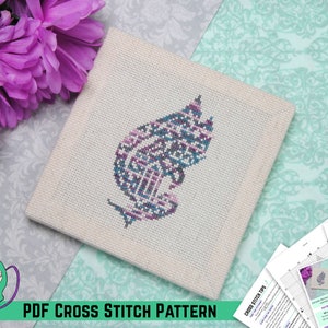 Puede incluir: Un patrón de punto de cruz PDF para un diseño de hoja estilizado azul y morado. El patrón incluye instrucciones y una tabla de colores.