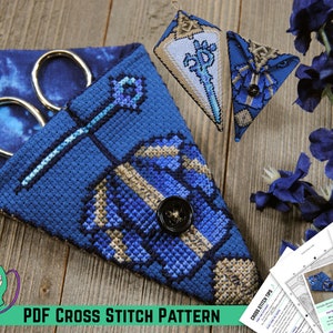 Könnte beinhalten: Ein blaues und goldenes Kreuzstichmuster für eine Schere. Das Muster enthält eine Nadel, Faden und einen Knopf. Das Muster ist als PDF-Download verfügbar.  PDF CROSS STITCH PATTERN