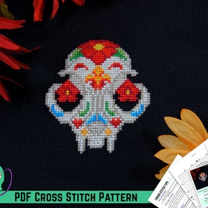 May include: A colorful cross stitch pattern of a sugar skull cat with red, yellow, blue, green, and white embroidery floss. The pattern is on black Aida cloth. The text "PDF CROSS STITCH PATTERN" is at the bottom of the image.