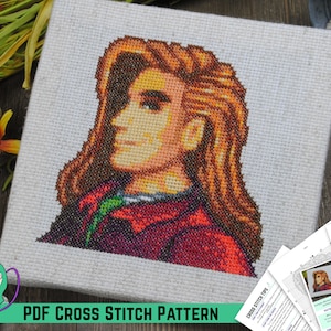 May include: A cross stitch pattern of a person with long brown hair, wearing a red and green jacket. The pattern is printed on white paper and includes instructions for stitching. The title of the pattern is "ELLIOT" and the text "PDF CROSS STITCH PATTERN" is printed at the bottom of the image.