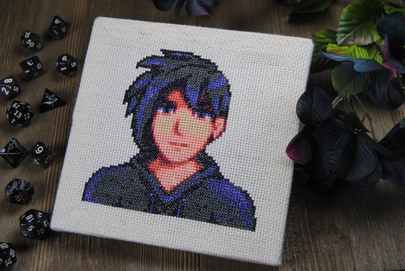 May include: Cross-stitch portrait of a person with blue hair and a purple hoodie. The person is looking directly at the viewer.