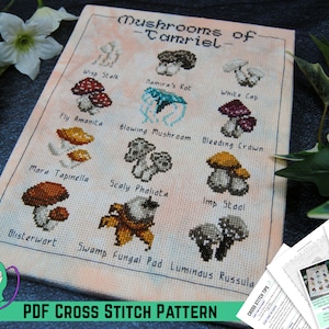 May include: A cross stitch pattern featuring a chart of 12 different mushrooms with their names, including "Wisp Stalk", "Namira's Rot", "White Cap", "Fly Amanita", "Blowing Mushroom", "Bleeding Crown", "Mara Tapinella", "Scaly Pholiata", "Imp Staal", "Blisterwart", "Swamp Fungal Pad", and "Luminous Russula". The pattern is titled "Mushrooms of Tamriel".