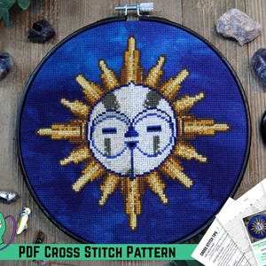 May include: A cross-stitch design in a black hoop, depicting a sun with a face against a blue backdrop. The sun has gold rays and a white face with glasses. The text "PDF CROSS STITCH PATTERN" is at the bottom.
