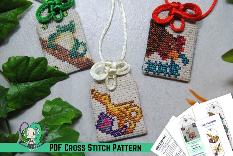 May include: Three cross-stitch pendants with different designs: a teapot, a bear, and a genie's lamp. Each pendant is on a cream-colored background with a decorative knot and cord. The text "PDF CROSS STITCH PATTERN" is at the bottom.