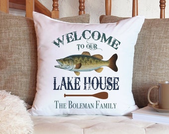 May include: White throw pillow with a blue and white graphic of a fish and the text "Welcome to our Lake House The Boleman Family".