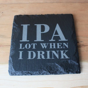 May include: Black slate coaster with the text "IPA Lot When I Drink" in white.
