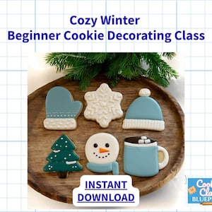 May include: A wooden tray holds six decorated winter-themed cookies. Designs include a mitten, snowflake, hat, Christmas tree, snowman, and a mug of hot chocolate. The text "Cozy Winter Beginner Cookie Decorating Class" is displayed above the cookies.