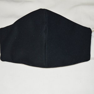 May include: A black face mask with white elastic ear loops.