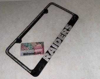 May include: A rectangular black license plate frame covered in small, sparkling clear crystals. The word RAIDERS is spelled out in large, clear crystal letters along the bottom edge. A small rectangular card with the text WeCrystalit.com is included.