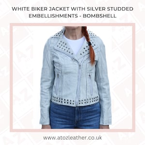 May include: A white denim biker jacket with silver studded embellishments. The jacket has a zipper closure and two zippered pockets on the front. The jacket is also decorated with silver studs on the collar, shoulders, and hem.