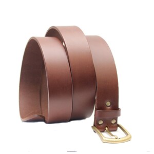 May include: A brown leather belt with a brass buckle. The belt is rolled up and the buckle is visible.