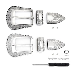 May include: Two silver belt buckles with intricate engraved designs. Each buckle comes with a matching tip and two screws. A small screwdriver is included for easy installation. EST. 2015.