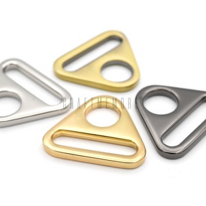 May include: Four triangle-shaped metal slider buckles in silver, gold, and black.