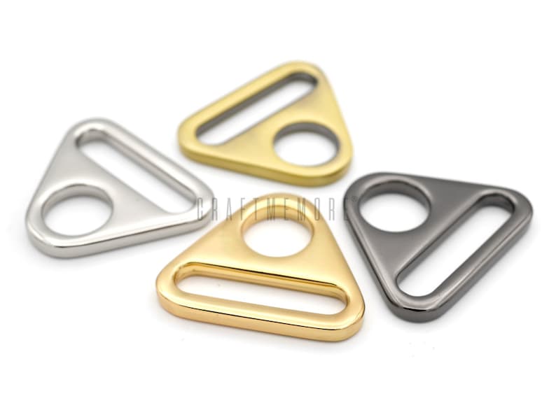 May include: Four triangle-shaped metal slider buckles in silver, gold, and black.