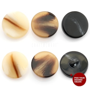 以下が含まれることがあります： 3色の丸いボタンが6つあります。色は、茶色とクリーム色、黒と白、茶色とクリーム色です。ボタンには渦巻き模様があります。