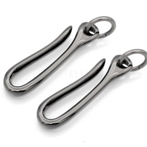 Pode incluir: Dois chaveiros de metal preto com um gancho e um anel. Os ganchos s&atilde;o curvos e os an&eacute;is s&atilde;o redondos.