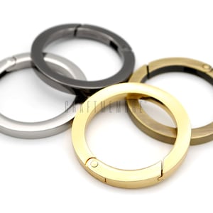 May include: Three metal key rings in silver, gold, and bronze. Each ring has a swivel clasp.