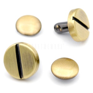 May include: Four brass-colored metal rivets with a black line down the center. Two of the rivets have a flat back, and two have a threaded back.