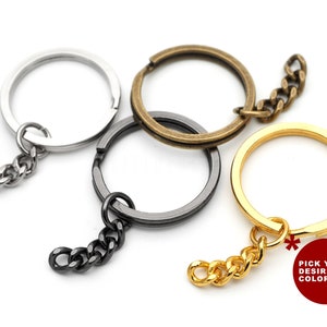 May include: Three keychains with different colored metal rings and chains. The rings are silver, gold, and bronze. The chains are silver, gold, and black. The text "Pick your desired color!" is visible in the image.