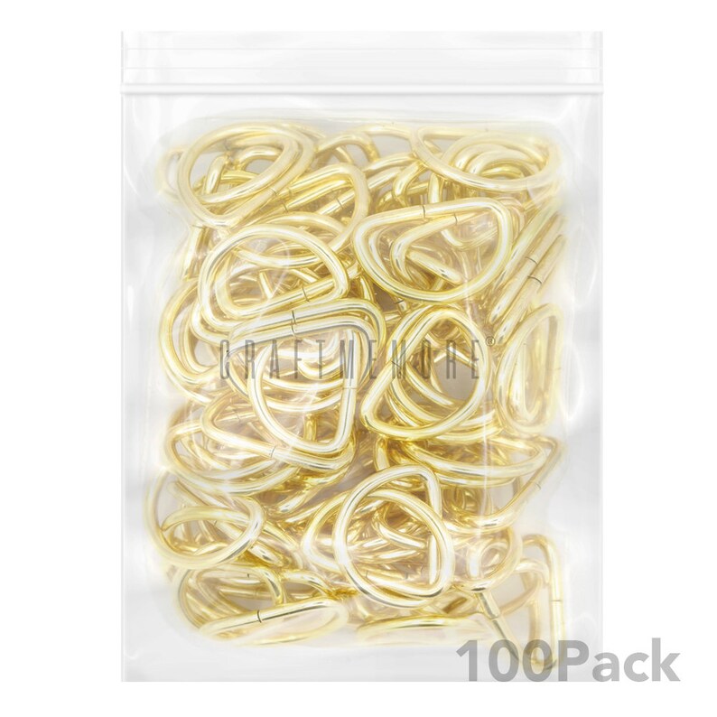 May include: A clear plastic bag filled with 100 gold-coloured metal D-rings. The bag has a zipper closure and the text "100Pack" is printed on the bottom of the bag.
