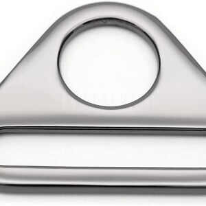 May include: A silver triangle-shaped metal ring with a large oval opening and a smaller rectangular opening. The ring is smooth and shiny.