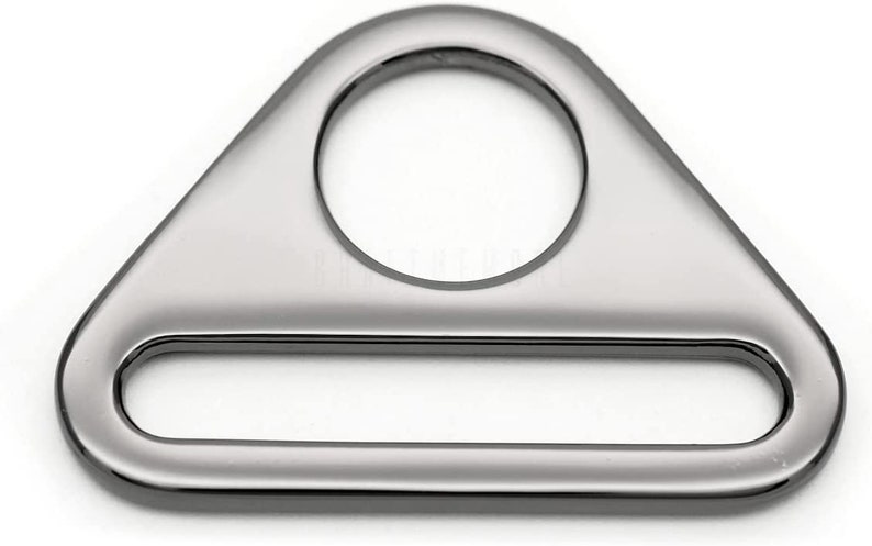 May include: A silver triangle-shaped metal ring with a large oval opening and a smaller rectangular opening. The ring is smooth and shiny.