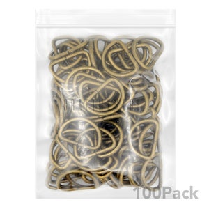 May include: A clear plastic bag filled with 100 gold-toned metal D-rings. The bag has a zipper closure and the text "100Pack" is printed on the bottom right corner.