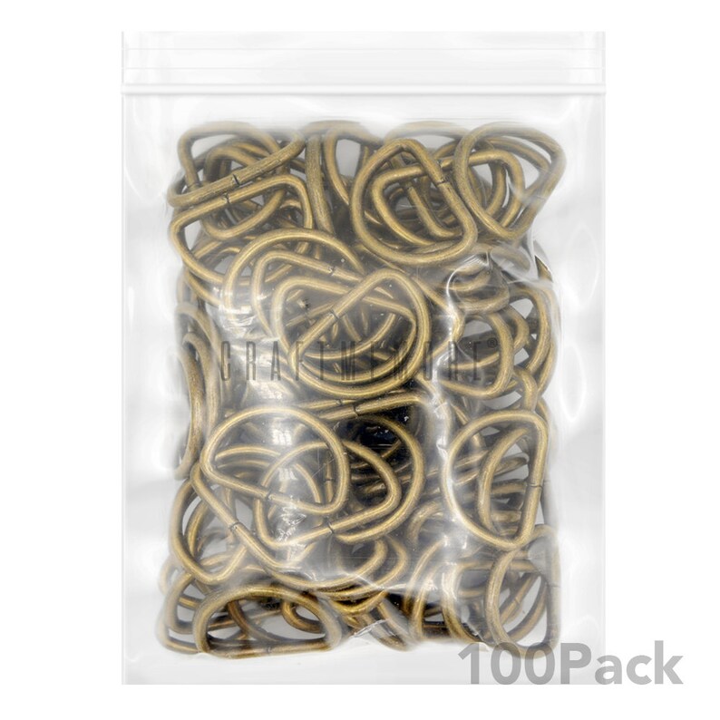 May include: A clear plastic bag filled with 100 gold-toned metal D-rings. The bag has a zipper closure and the text "100Pack" is printed on the bottom right corner.
