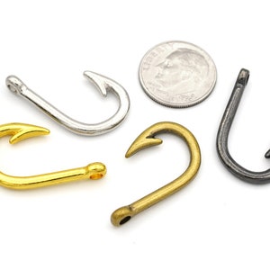 May include: Four different metal fishing hooks in gold, silver, bronze, and black.