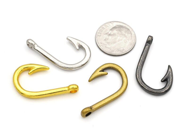 May include: Four different metal fishing hooks in gold, silver, bronze, and black.