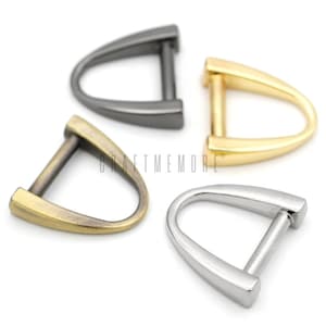 Op de afbeelding: Vier metalen D-ring beslagstukken in verschillende afwerkingen: zwart, goud, antiek messing en zilver. Deze zijn geweldig voor lederbewerking, tassen maken en sieraden maken.