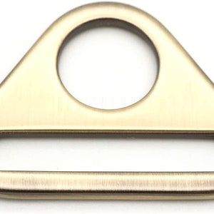 May include: A gold-toned metal triangle-shaped buckle with a round hole and a rectangular slot.