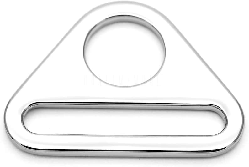 May include: A silver triangle-shaped metal loop with a large round hole and a smaller rectangular hole.