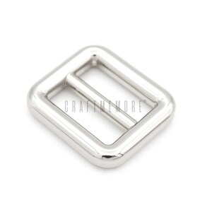 May include: Silver metal buckle with a rectangular shape and a smooth finish.