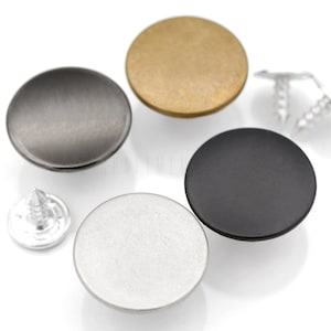 May include: A selection of round metal buttons in silver, black, brass, and gunmetal finishes. Includes silver rivets. Suitable for clothing or crafts. The buttons have a smooth, matte finish. Ideal for various projects.