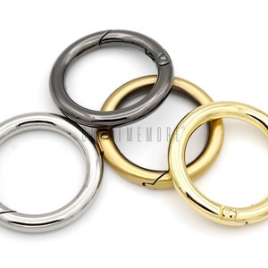 May include: Three metal key rings in different finishes: silver, gold, and black. Each ring has a swivel clasp.